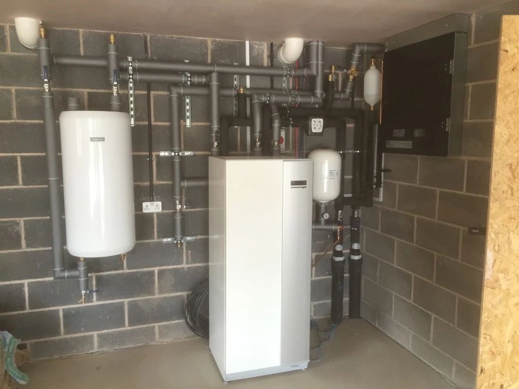 Indoor heat pump unit with insulated pipework in a plant room